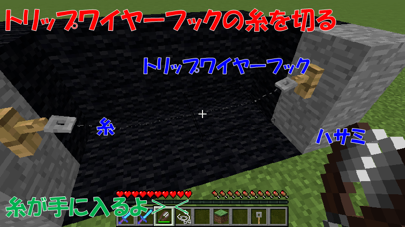 ハサミでトリップワイヤーフックの糸を切る